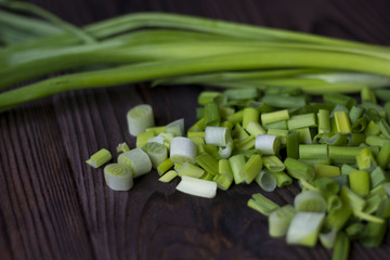 chopped onions and green onions on a wooden table