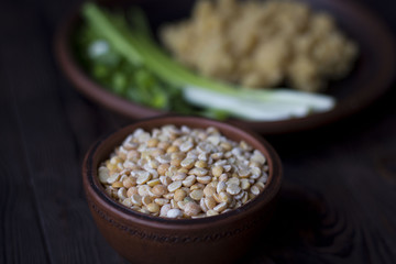 pea porridge, peas and onions in a clay pot on a wooden table