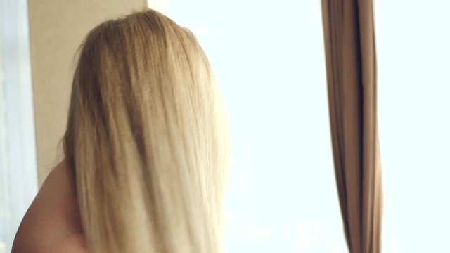 Slow movement of female dry wet hair. A female woman uses a hairdryer in the bathroom. 4k