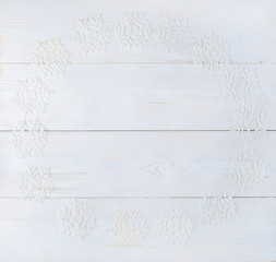 Light wooden texture background surface with decoration snowflakes. Top view, flat lay. Concept of Merry Christmas and Happy New Year