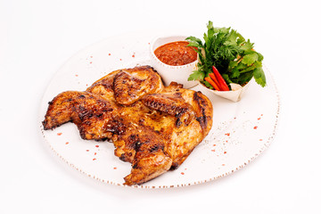 Grilled chicken Tabaka with sauce on a plate on white background for menus.