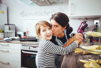 mutter und tochter backen plätzchen in der vorweihnachtszeit