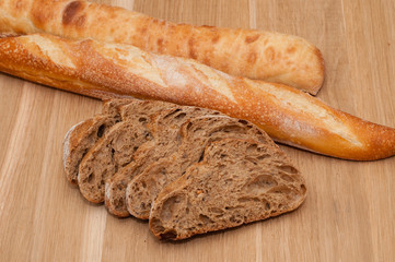 sliced French black bread and two baguettes