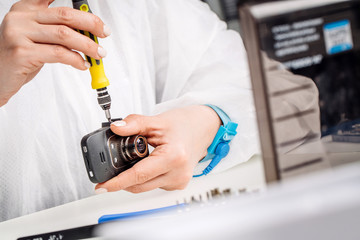 Close up hands of a service worker repairing Car DVR Front camera recorder.