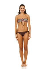 Fototapeta premium Young pretty brunette posing in bikini on white background