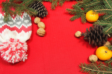Christmas tree toys on a red napkin. Mandarins and candles on th