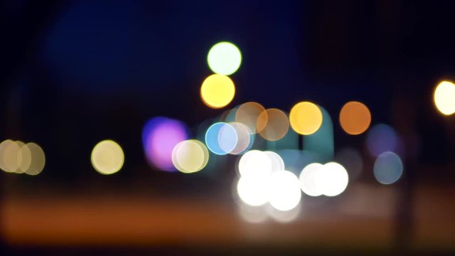 Defocused lights of moving cars. Night Traffic in the city with blurred motion. The bokeh effect. Light car bokeh moving on the road.