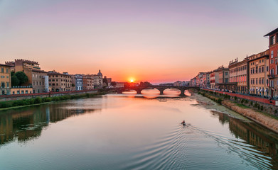 Obraz premium Sunset time in Florence, Italy. Bright sky over Arno river and medieval bridge.