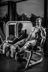 Naklejka premium Leg Exercises - Man Doing Leg With Machine In Gym