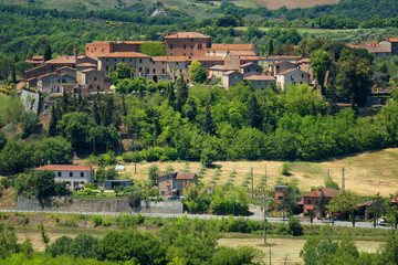 Magnificent spring landscape.Beautiful view of typical tuscan farm house, green wave hills, cypresses trees, hay bales, olive trees, beautiful golden fields and meadows.Tuscany, Italy, Europe