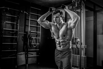 Fototapeta na wymiar Sexy muscular man posing in gym, shaped abdominal. Strong male n