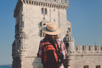 Back view of tourist looking at the Belem Tower in Lisbon Portugal on sunshine blue sky outdoors...