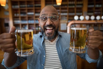 Smiling man having glasses of beer in restaurant
