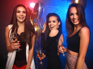 party, holidays, celebration, nightlife and people concept - smiling friends dancing in club
