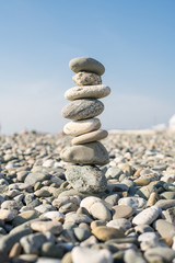 Fototapeta na wymiar Pyramid of stones on the beach. Stone tower
