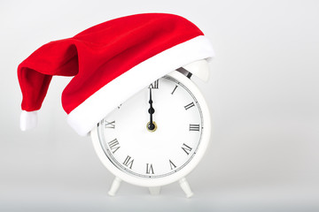 Vintage alarm clock in Santa Claus hat.