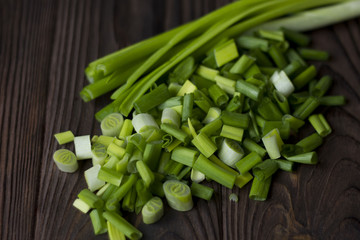 chopped onions and green onions on a wooden table