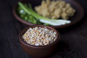 pea porridge, peas and onions in a clay pot on a wooden table