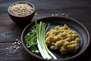 pea porridge, peas and onions in a clay pot on a wooden table