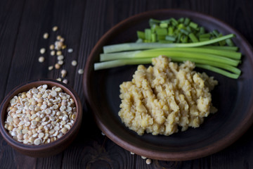 pea porridge, peas and onions in a clay pot on a wooden table
