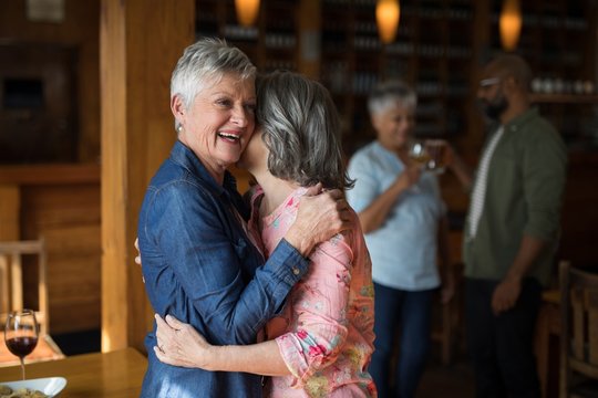 Two senior female friends embracing each other 