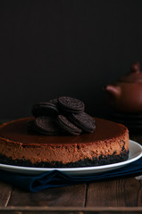 Chocolate cheesecake with cookies on a white plate.