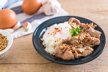 stir-fried pork with garlic on topped rice with egg