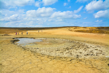 Fototapeta na wymiar Tourists in the valley of mud volcanoes