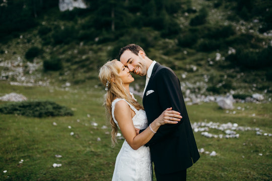 Wedding couple are posing in the Alps at summer 