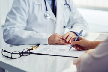 Female patient in office signing a document