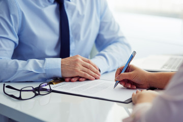 Female client signs a contract in the office