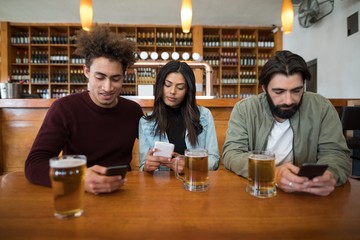 Friends using mobile phone on table