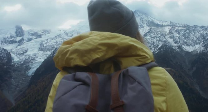 CRANE SHOT Beautiful Caucasian female hipster hiking in French Alps, enjoying the view of Mont Blanc massif. 4K UHD RAW 60 FPS SLO MO