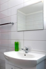 Fragment of the bathroom with a washbasin and a mirror