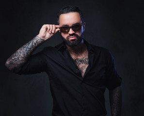 Fototapeta premium A man with tattoos on arms and neck.