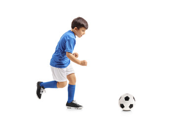 Little footballer running towards a football