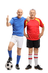 Two elderly soccer players with one of them making a thumb up gesture