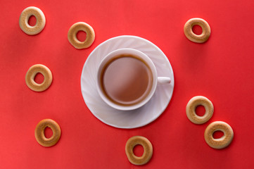 Tea and bagels on a red background top view