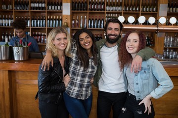 Friends standing together with arm around at counter