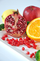 Fresh Pomegranate with Colorful Fruits on Background