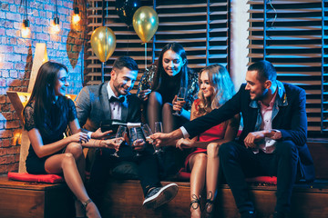 Group of friends enjoying party pouring champagne and having fun