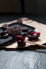 chocolate chip cookies and jam on paper on a black plate