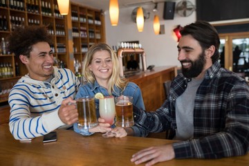 Friends toasting glass of drinks in bar