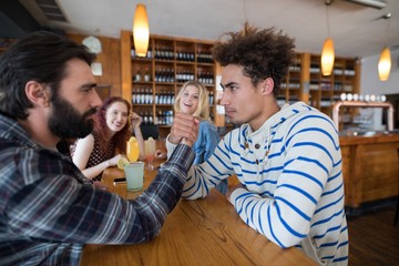 Two men arm wrestling in bar