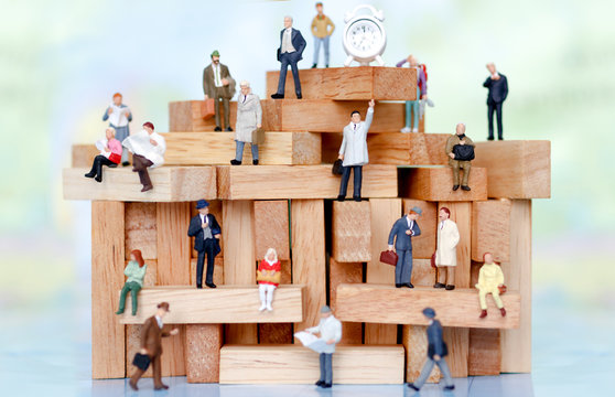 Miniature business people sitting on wood block , recruitment finding employee and business concept.