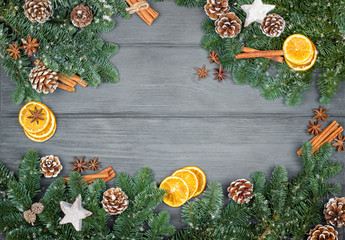 Christmas decorations on a wooden background with cinnamon and dried orange slices, copy space.