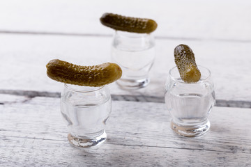 vodka shots with pickled cucumber on bar counter