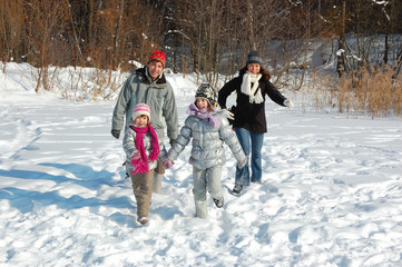 Happy family walks in winter, having fun and playing with snow outdoors on holiday weekend
