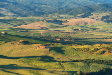 Magnificent spring landscape.Beautiful view of typical tuscan farm house, green wave hills, cypresses trees, hay bales, olive trees, beautiful golden fields and meadows.Tuscany, Italy, Europe