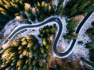 Aerial view of snowy forest with a road. Captured from above with a drone